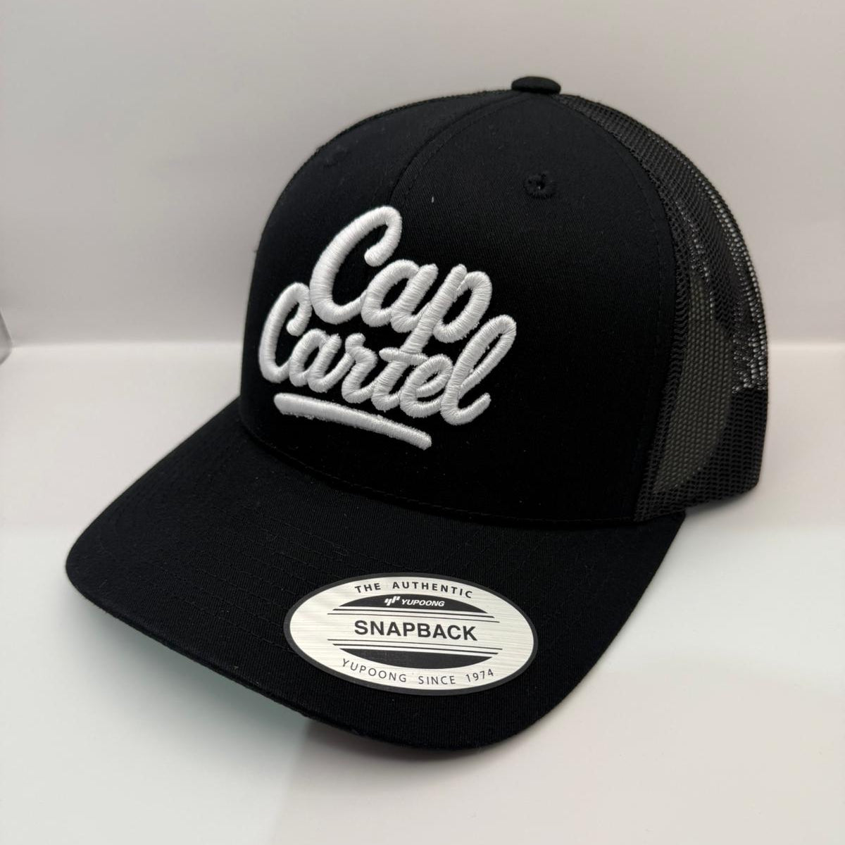 Black cap with 'Cap Cartel' logo on a white background